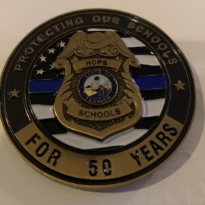 A police badge with the words protecting our schools for 5 0 years written on it.