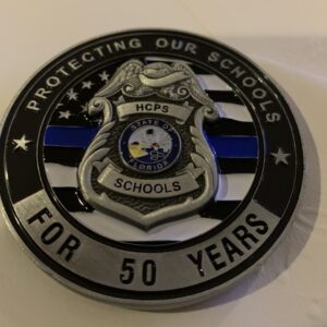 A police badge with the words protecting our schools for 5 0 years.